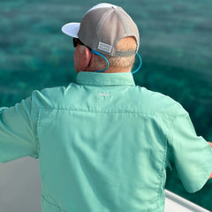 Man overlooking the ocean while fishing wearing Dorado Explorer microfiber material shirt. Lightweight and ventilated, this shirt is a great fit for men for outdoor adventure.