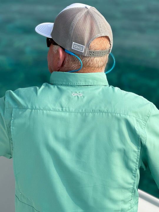 Man overlooking the ocean while fishing wearing Dorado Explorer microfiber material shirt. Lightweight and ventilated, this shirt is a great fit for men for outdoor adventure.