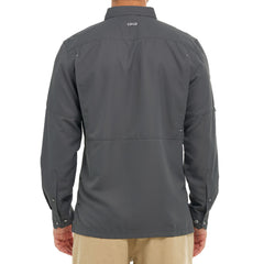Back view of man wearing a dark gray long-sleeve outdoor shirt with button cuffs and tan pants.