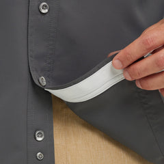 Close-up of built-in lens cleaner detail on dark gray outdoor button-up shirt.