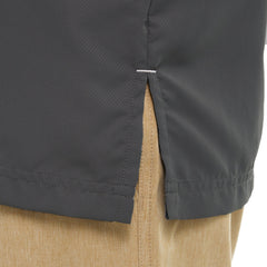 Close-up of side seam and vent detail on dark gray outdoor shirt paired with tan pants.