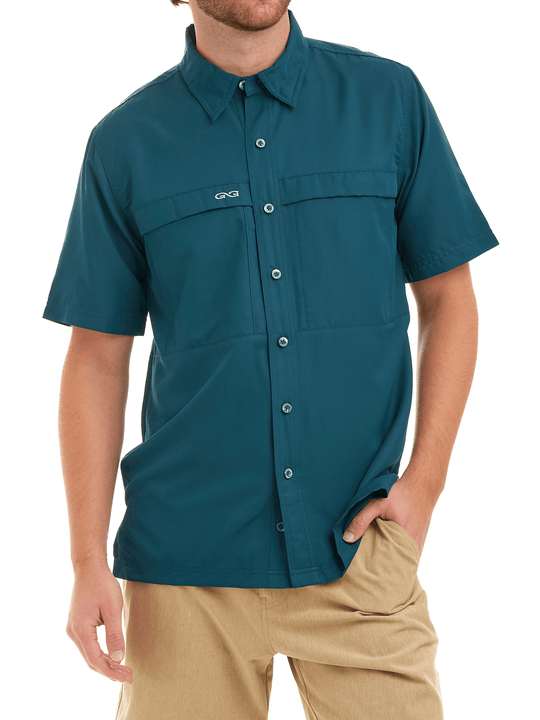 Man wearing a teal short-sleeve shirt with a brand logo on a white background