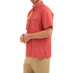 Man wearing a red shirt and beige pants on a white background