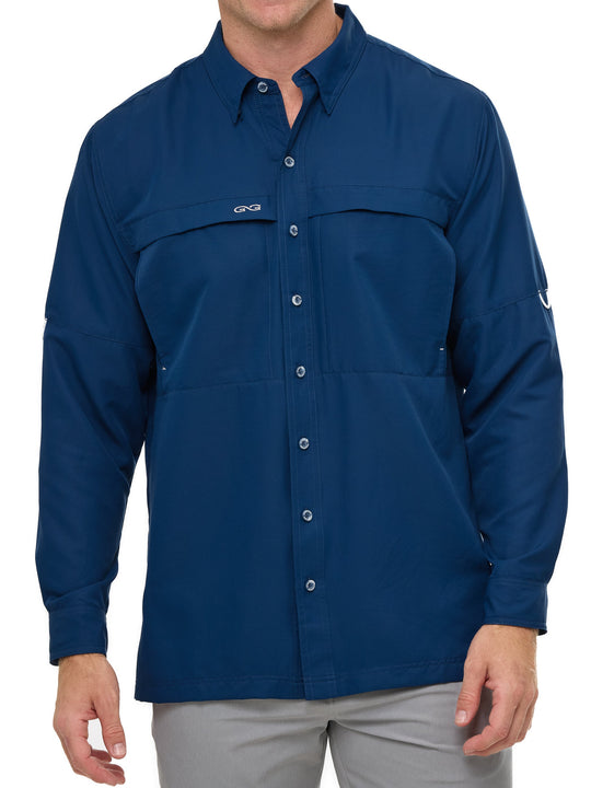 Man wearing Deep Water blue GameGuard Original long sleeve shirt with mesh vents, roll-up sleeves, GG logos, and utility loop; made for fishing and sun protection.