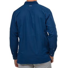 Man wearing Deep Water blue GameGuard Original long sleeve shirt with mesh vents, roll-up sleeves, GG logos, and utility loop; made for fishing and sun protection.