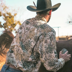GameGuard Explorer Shirt | Long Sleeve-GameGuard - man brushing horse in the outdoors wearing GameGuard camo, built to blend into the southwest enviornment during a hunt and maintaining durability while working